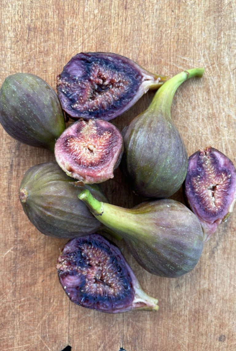 A selection of ripe Brown Turkey Figs on wooden chopping board.