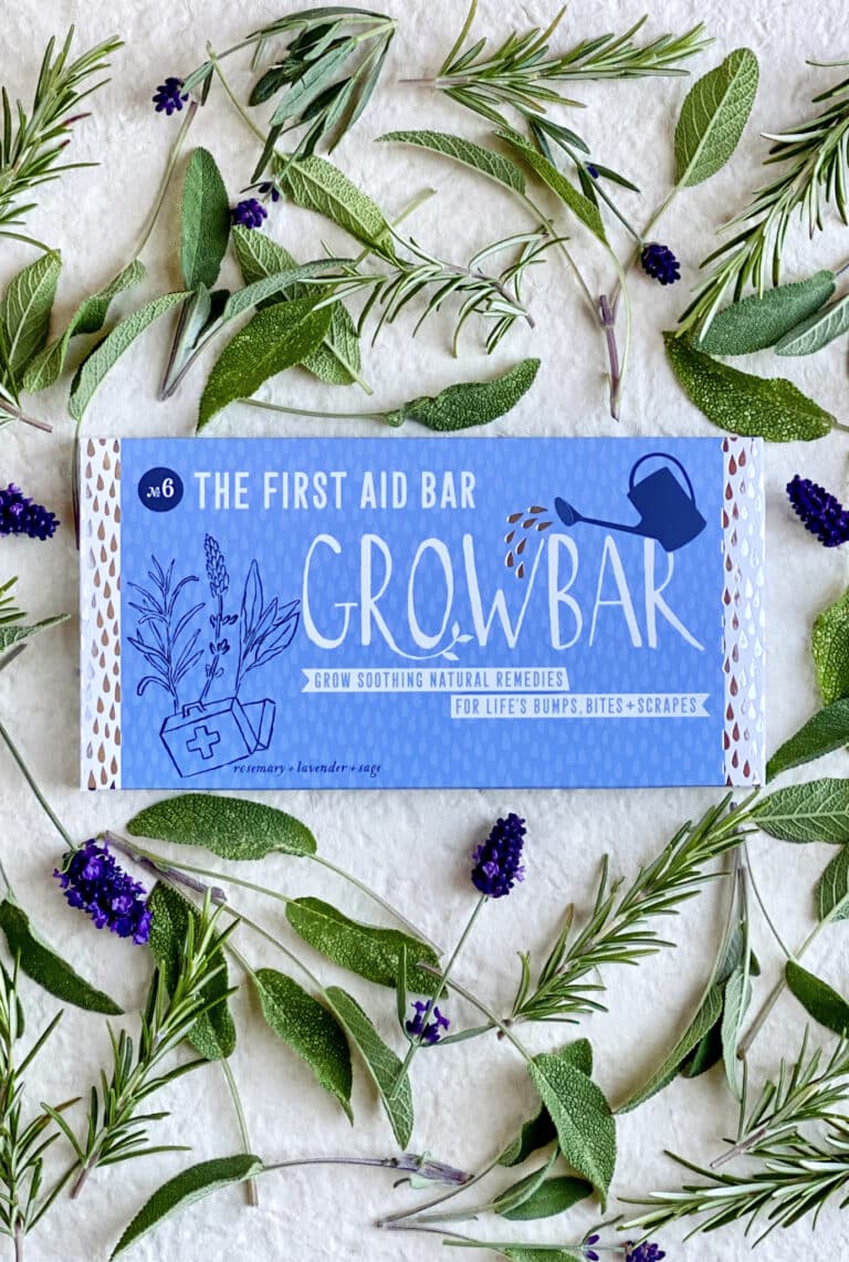 A bright blue illustrated Growbar package surrounded by fresh green twigs of Rosemary, Sage and deep purple Lavender flowers.