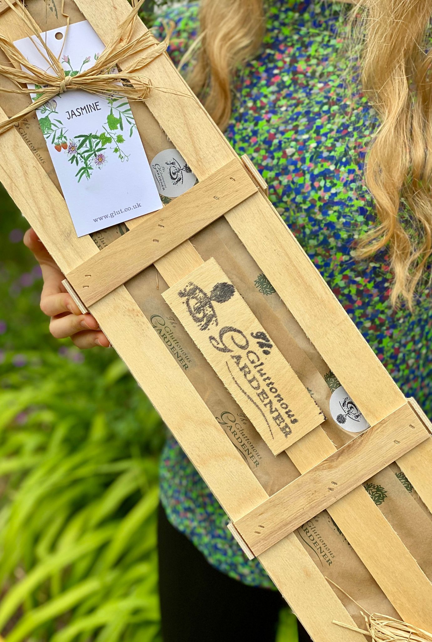 Wooden Jasmine Crate with twine and gift tag being held.