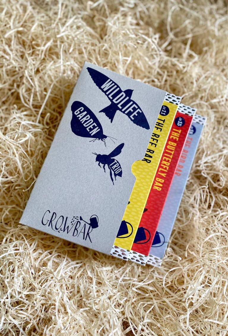 A wildlife garden trio box containing three different growbars in red. beige and blue colour, nestled in wood wool.