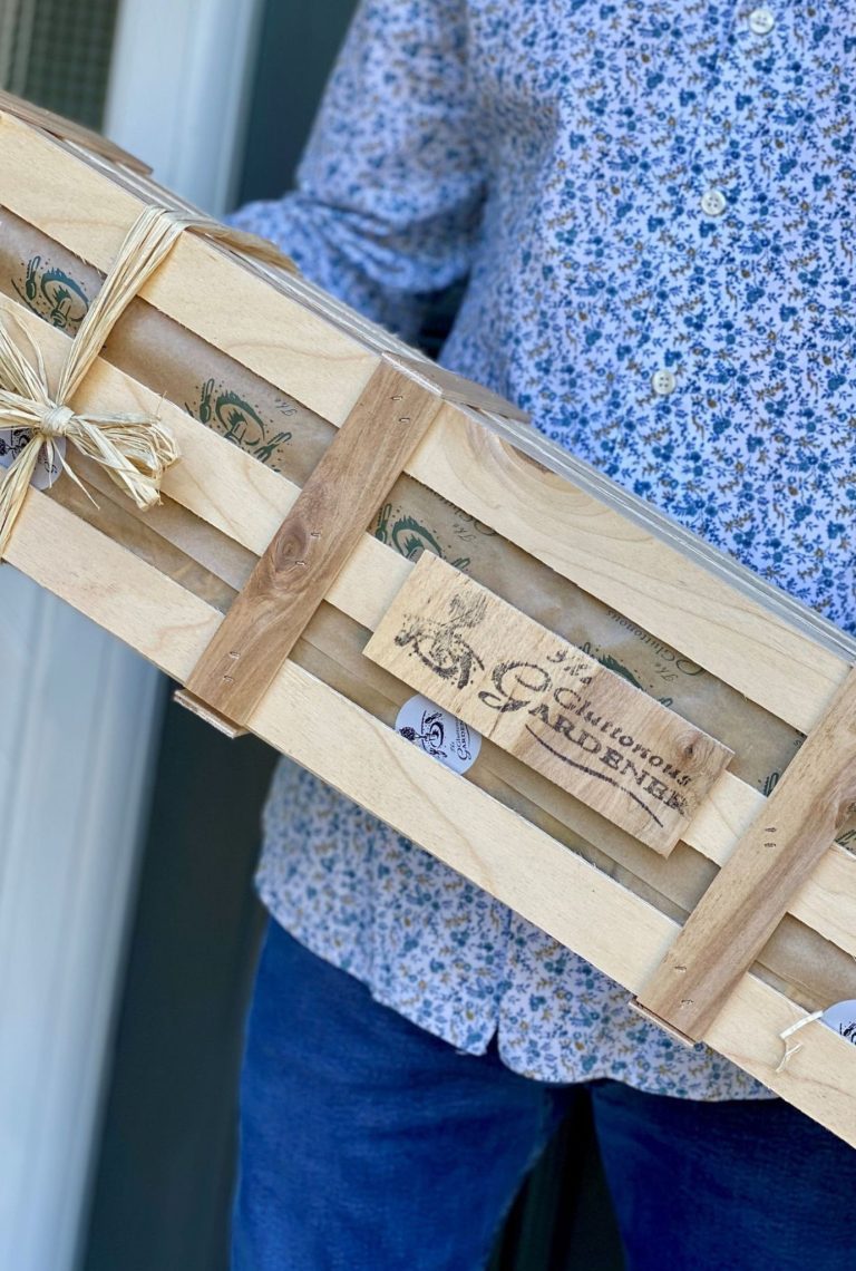 Wooden crate being held by man in blue top.