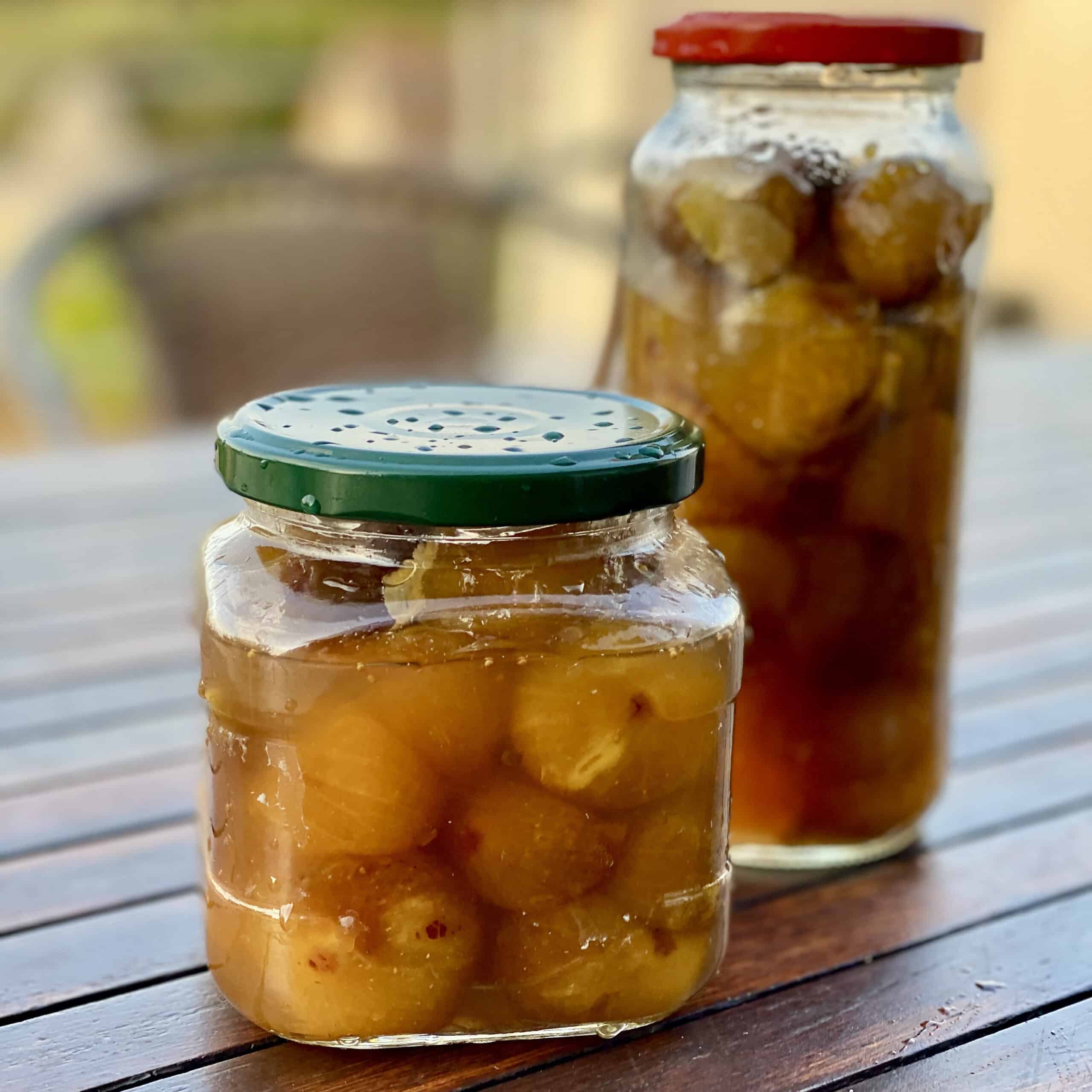 Two jars of preserved figs on a wooden table.