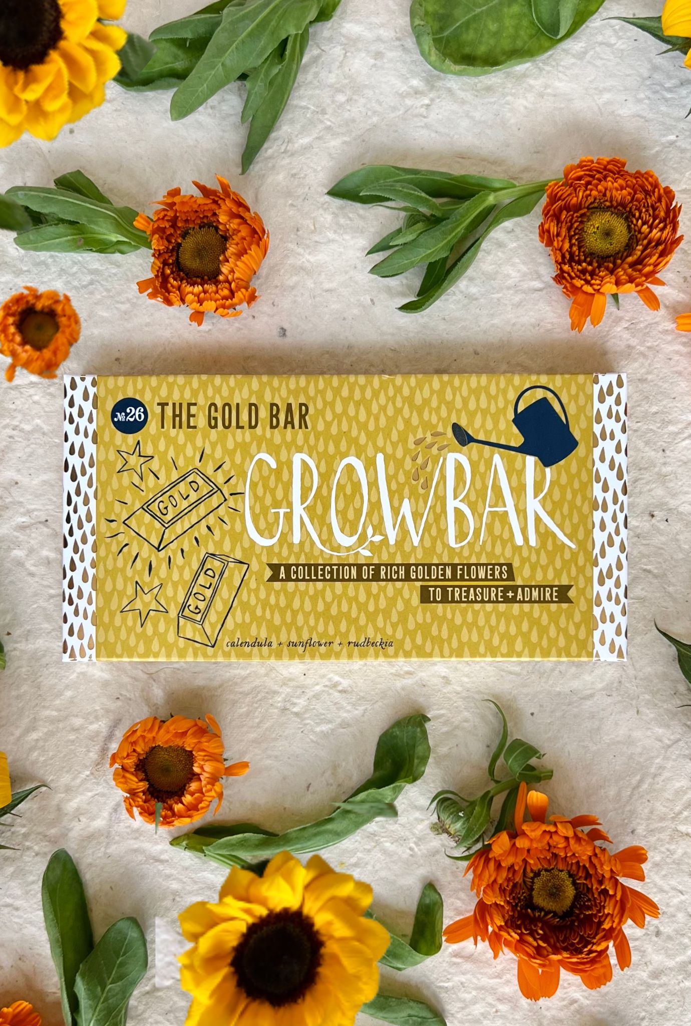 The Gold Bar against a white background displayed with vibrant orange and yellow flowers from the bar.