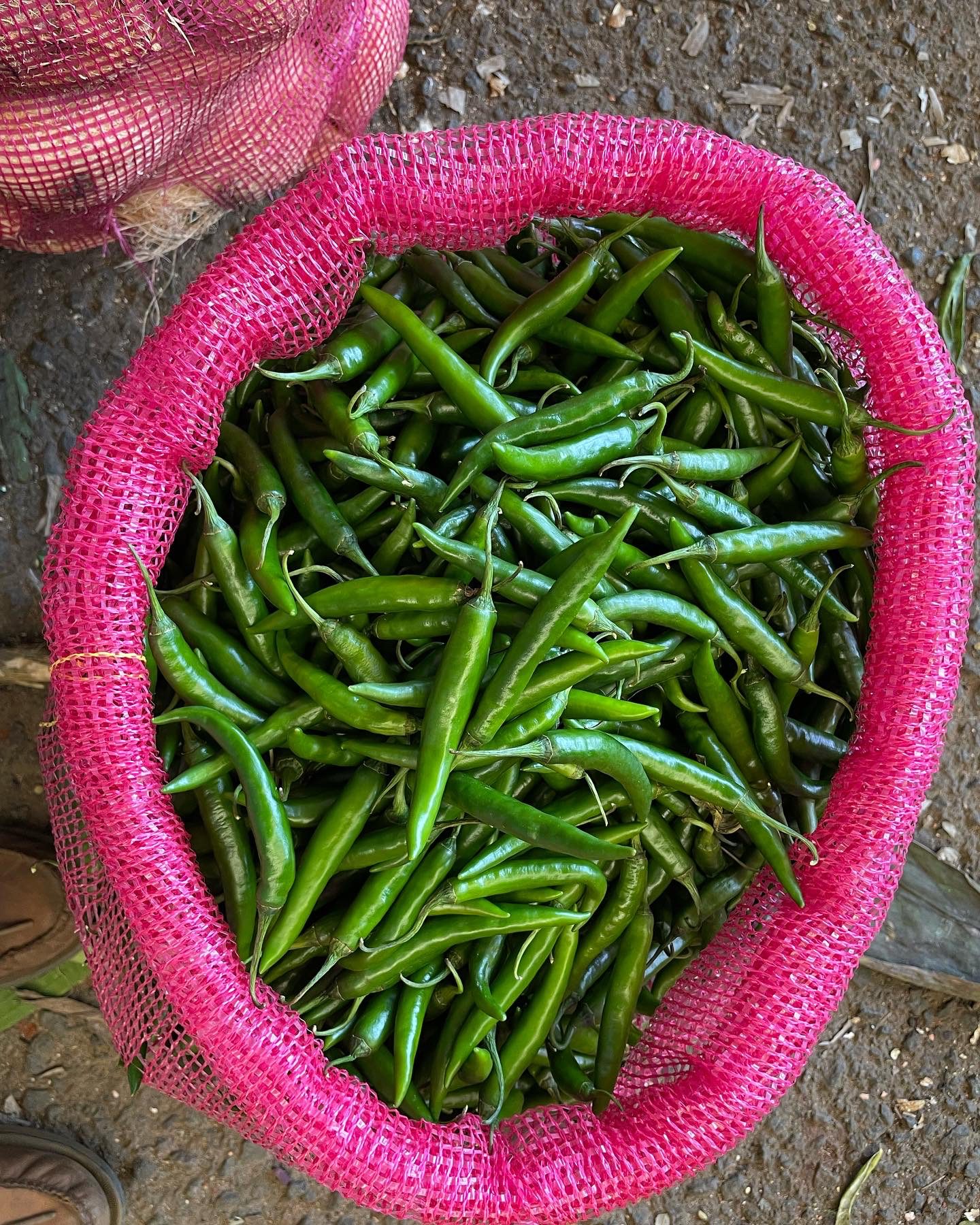 Pink bag of green chili peppers.