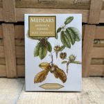 Close up of Medlars Growing & Cooking book in front of two wooden crates.