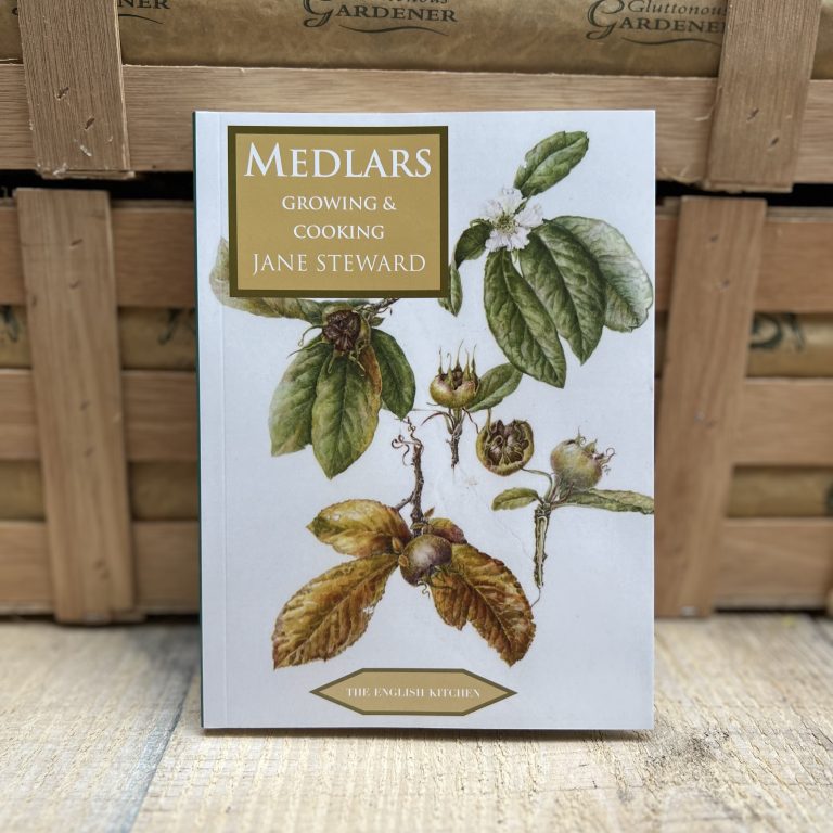 Close up of Medlars Growing & Cooking book in front of two wooden crates.
